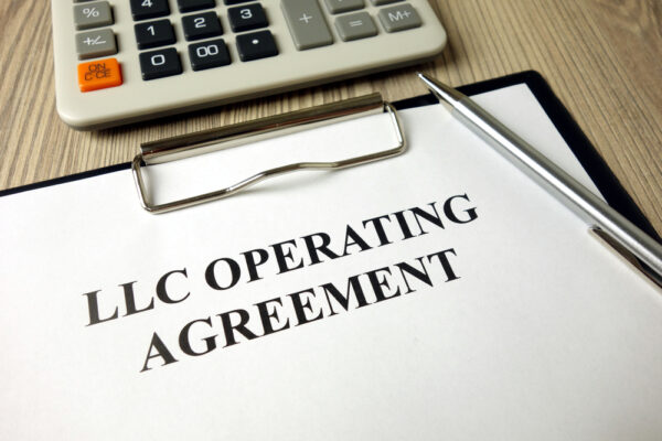 clipboard holding a sheet of paper that says "LLC Operating Agreement"