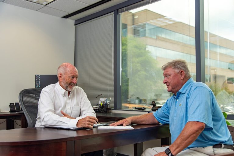 Ed-with-Enoch-Tarver-Sitting-at-A-Desk-With-Client